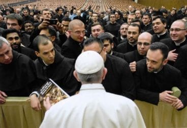 A priest presents the Pope with the book